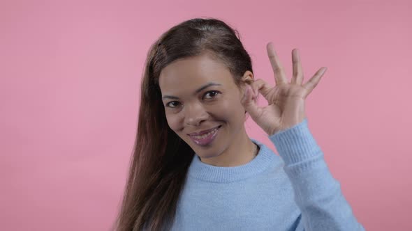 African Woman Showing Ok Sign Over Pink Studio Background