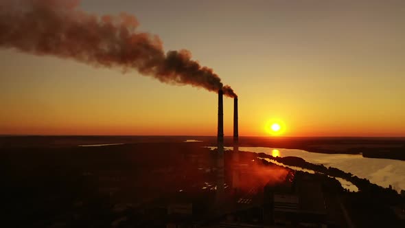 Industrial landscape from drone view. Factory chimney piping smoke into the air pollution during sun