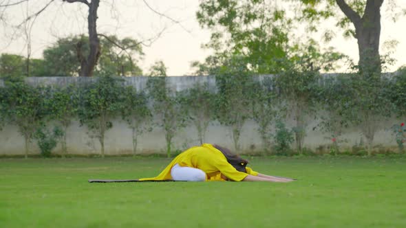 Yoga is being done by an Indian woman in a park