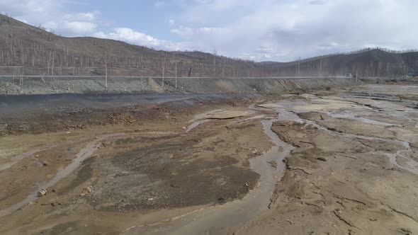 Aerial view of dry riverbed poisoned. Near the road. Cars are driving along the road 29