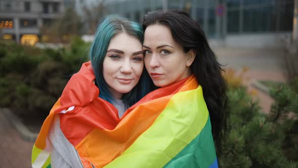 Lesbian Couple Hugging Covered with Rainbow Flag in Public