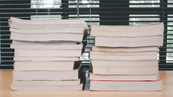 Stop motion animation stacks books on wooden desk.