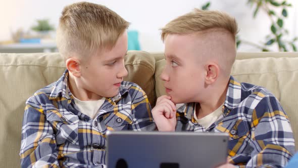 9 Year Old Twin Brothers Sitting on Couch with Tablet alt
