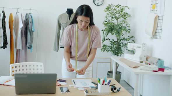 Slow Motion of Young Asian Woman Clothes Designer Choosing Material and Color for New Garment