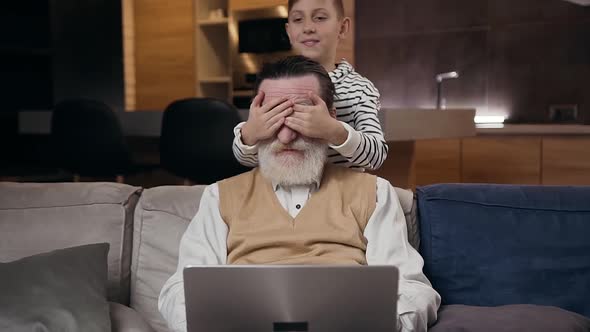 Man which Working on Computer at Home Until then His Teenage Grandson Unexpectedly Closed his eyes