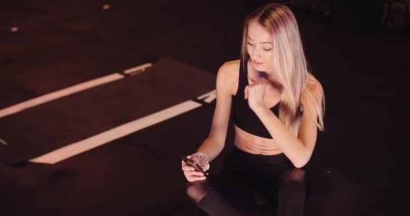 Female Athlete Using Mobile Phone At Gym