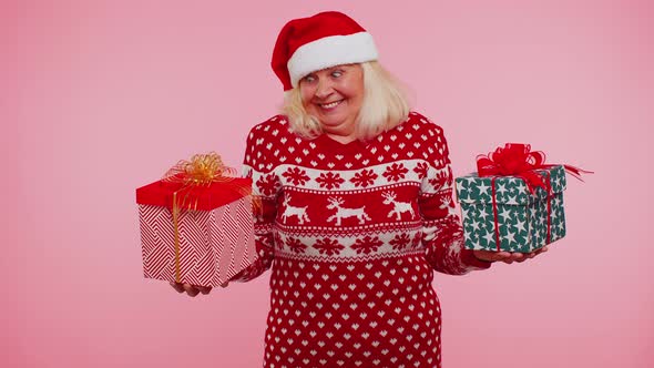 Senior Grandmother Woman in Christmas Sweater Holds Two Gift Boxes in Hands Shopping Holidays Sale