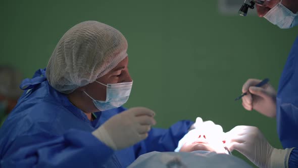 Caucasian Nurse and Surgeon Performing Operation Eyelid Surgery in Medical Clinic Indoors