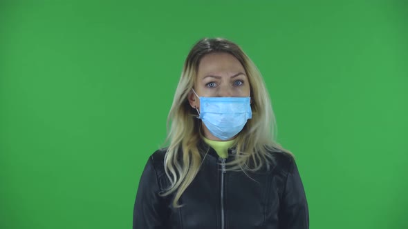 Portrait of Beautiful Young Upset Woman in Medical Protective Face Mask Is Looking at Camera Gets