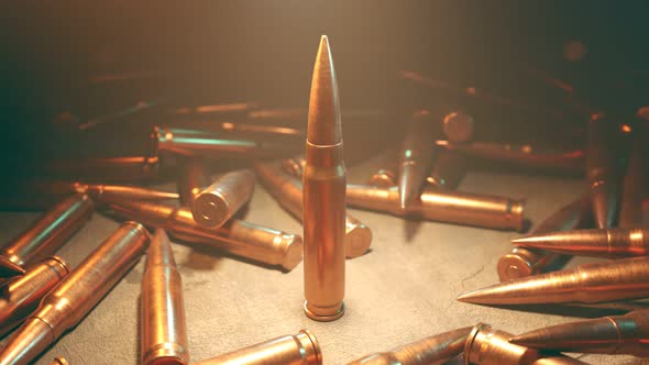 Closeup of the one standing bullet in the spotlight surrounded by scattered ammo