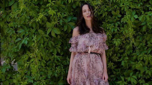 Stylish Hipster Girl Posing Over Green Leaves Bush Background