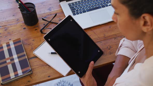 Caucasian woman using digital tablet, working from home