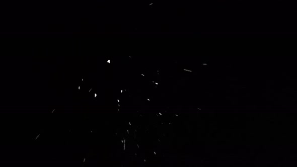 Footage looking straight up at a dark sky with snow dramatically falling towards the camera.