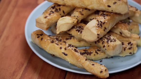 baked dough sticks covered with seeds on the baking sheet.