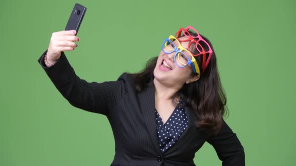 Mature Beautiful Asian Businesswoman Using Phone While Wearing Many Eyeglasses As Funny Concept