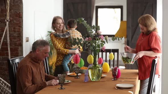 Family is eating at Easter dinner sitting at the table at home