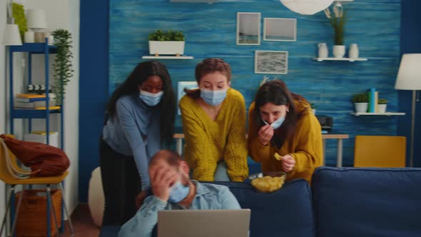 Multi Ethnic Friends Wearing Face Mask Eating Snacks Using Laptop