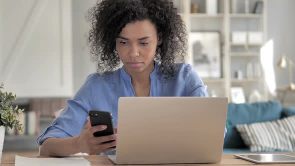 African Woman Using Smartphone at Workplace