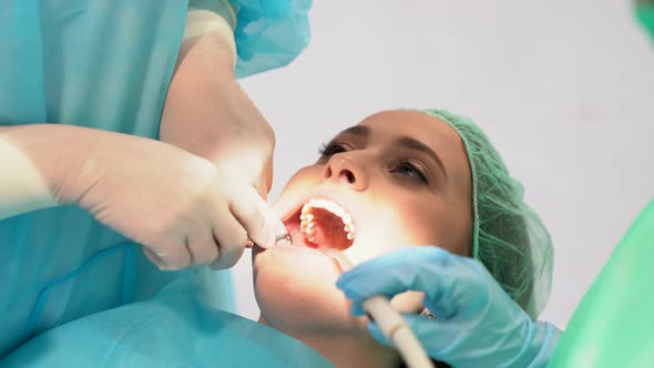 Dentist and his assistant examining the teeth of a patient