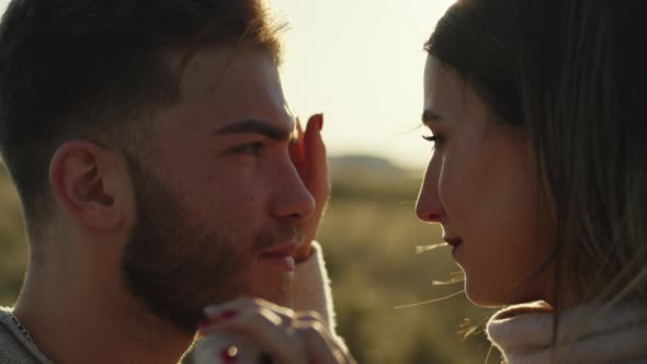 Girl cuddles her boyfriend at sunset