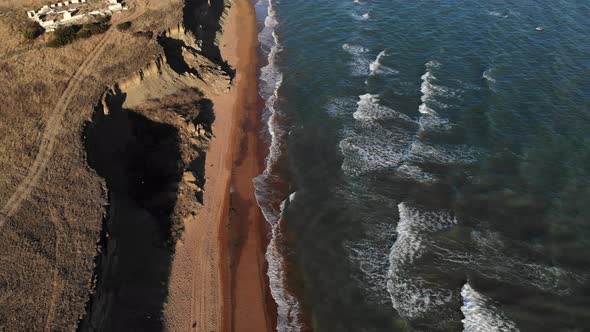 Aerial View of Sandy Steep Seashore During Wind
