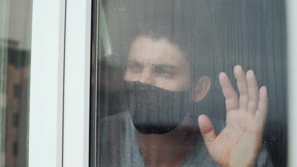 sad man medical mask walks window look outside during quarantine due coronavirus