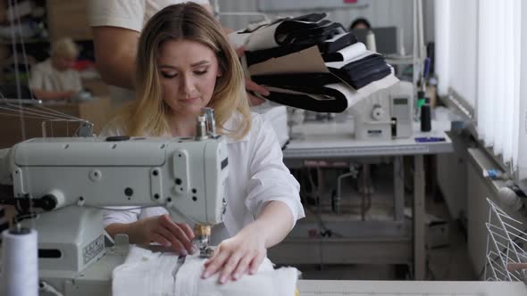 Young Beautiful Light Hair Seamstress Gets More Work to Do in the Workplace