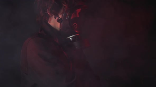 A man in a gas mask in the smoke. black background