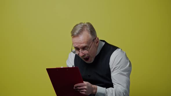 Funny mature man with a folder isolated on yellow wall