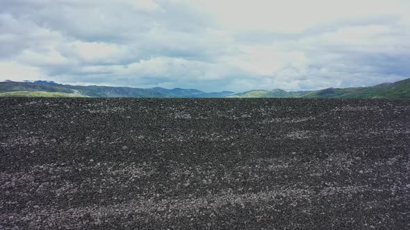 Massive rocky man-made landfill at Hardangervidda - Approaching wall of stone while descending - Sym