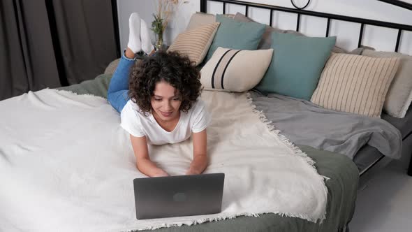 Smiling Hispanic Curly Woman Student Study Uses Laptop Distance Education