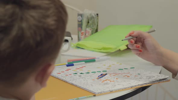 A boy and his mother coloring a picture