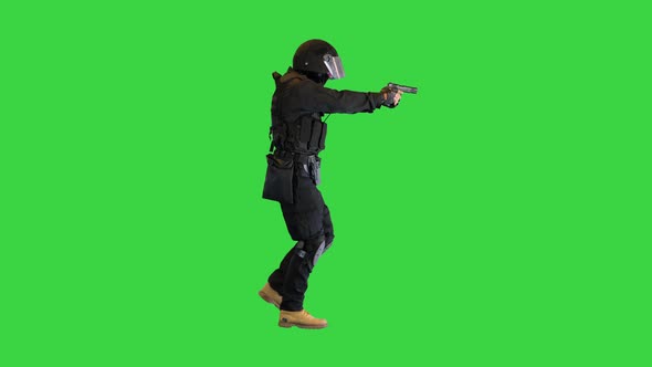 Armed Man in Protective Cask with a Pistol Walking Aiming on a Green Screen Chroma Key