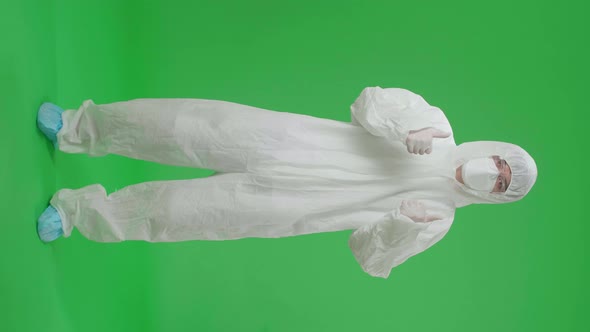 Full Body Of Asian Male Wear Protective Uniform Ppe And Showing Thumbs Up In Green Screen Studio
