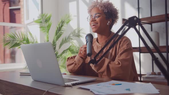 Woman Blogger Streams Online Using Laptop Studio Microphone and Earphones