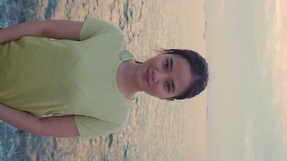 Smiling of portrait woman wearing sportswear standing at seaside and looking at camera.