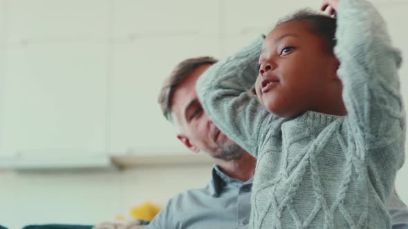 Positive mature father talking with his adopted daughter