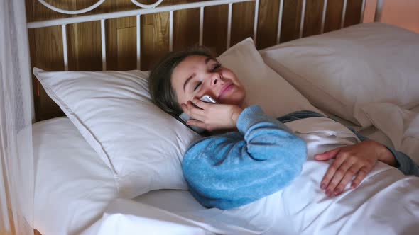 Woman in Bed Dialing Call and Talking on Phone