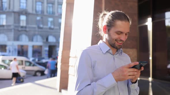 Business Man Using Mobile Phone Outdoors On Sunny Day At Street