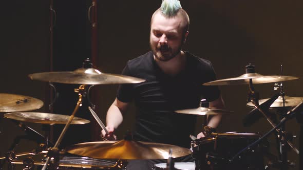 Hard rock drummer performing in a studio setting.