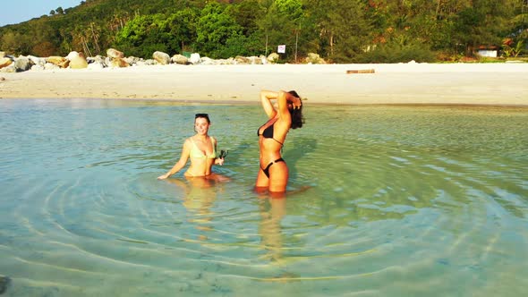 Tourists relaxing on idyllic coastline beach wildlife by blue ocean and white sand background of Koh