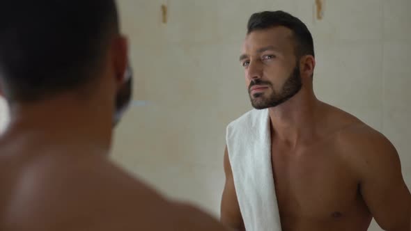 Man Applying Aftershave Lotion to Face in Bathroom, Prevention of Skin Dryness