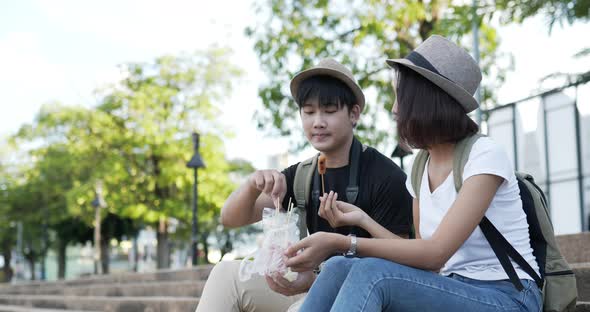 Couple eating sausage at the park