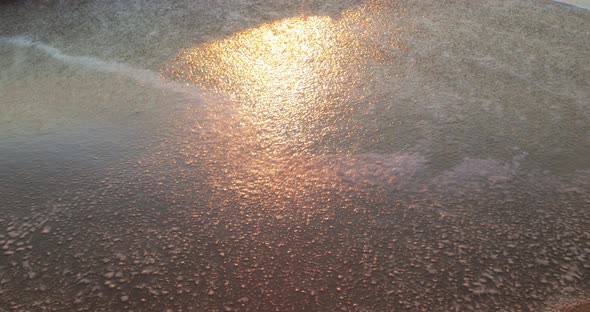 Calm Waves of the Archipelago Slowly Break on the Sandy Beach at Dawn in Summer