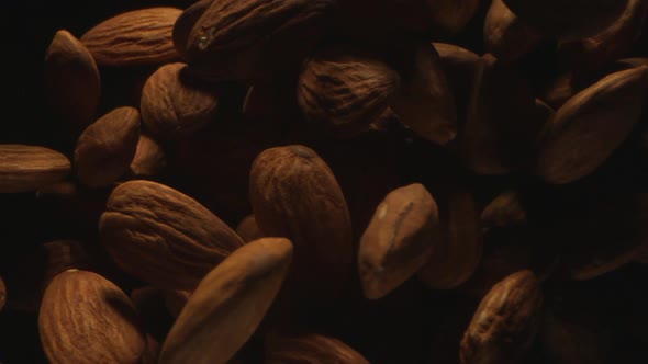 Almonds Are Tossed In The Air On A Black Background