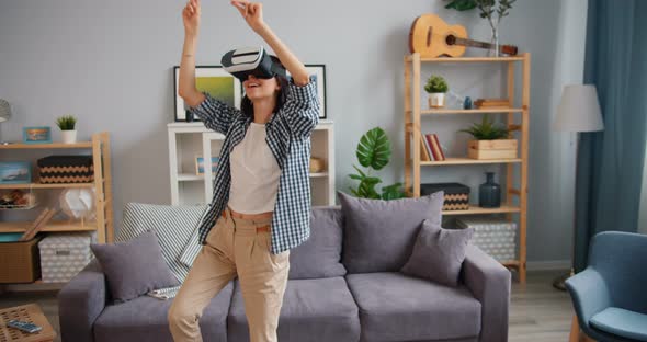 Joyful Hipster Having Fun Dancing Relaxing in Virtual Reality Glasses in House