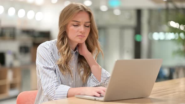 Tired Businesswoman with Laptop Having Neck Pain in Office 