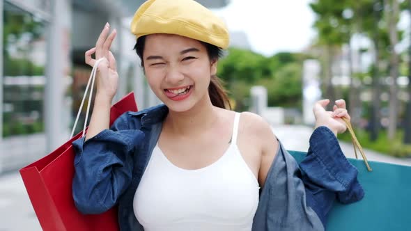 Smiling young Asian woman with shopping colour bags