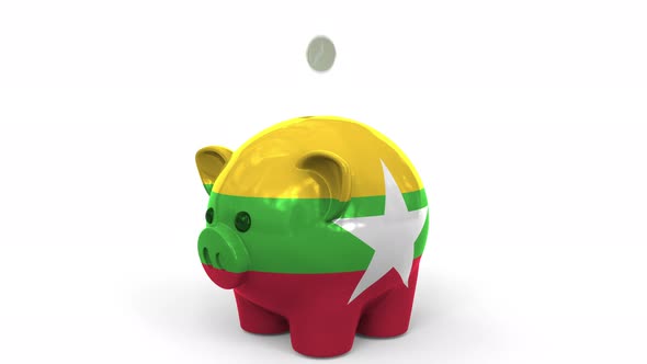 Coins Fall Into Piggy Bank Painted with Flag of Myanmar