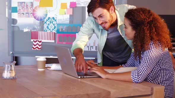 Graphic designers using laptop at desk